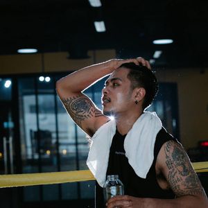 A bottle of water and a towel on the floor, essentials for a training session.